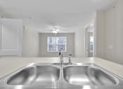Thumbnail 16 of 25 - A modern kitchen with a double sink and a window.