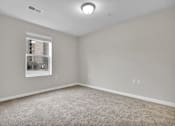 Thumbnail 5 of 25 - A room with a window and a carpeted floor.