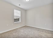 Thumbnail 17 of 25 - A room with a window and carpeted floor.