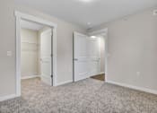 Thumbnail 24 of 25 - A room with two white doors and a carpeted floor.