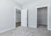 Thumbnail 21 of 22 - A room with a carpeted floor and two open doors.