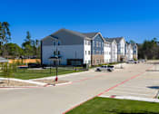 Thumbnail 9 of 22 - A parking lot in front of a building with a gazebo in the foreground.