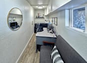 Thumbnail 5 of 14 - Leasing office with a couch, chair, desk, mirror, and window on the right wall.