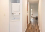 Thumbnail 10 of 19 - A long hallway with a washer and dryer to the left at our apartments for rent in Renton, WA