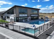 Thumbnail 10 of 36 - a swimming pool in front of a building with a patio and a poolside building at Yellowstone Landing, Montana