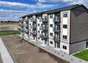 Thumbnail 6 of 36 - an aerial view of an apartment building with green grass and a parking lot at Yellowstone Landing, Belgrade, MT, 59714