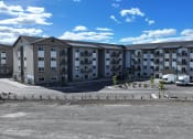 Thumbnail 3 of 36 - a large apartment building sitting in a parking lot at Yellowstone Landing, Belgrade, MT, 59714