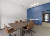 Thumbnail 19 of 36 - a conference room with a wooden table and chairs and a blue wall at Yellowstone Landing, Belgrade, 59714