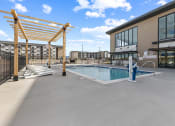 Thumbnail 15 of 36 - the pool area of a building with a pool and lounge chairs at Yellowstone Landing, Belgrade, MT, 59714