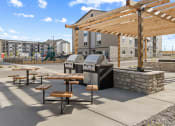 Thumbnail 14 of 36 - a picnic area with tables and a grill in front of a building at Yellowstone Landing, Belgrade