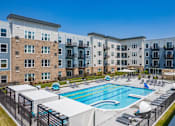 Thumbnail 19 of 26 - an outdoor swimming pool with an apartment building in the background