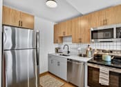 Thumbnail 6 of 33 - Modern kitchen with a stainless steel refrigerator and oven at Reflections at the Wharf, Washington, DC, District of Columbia