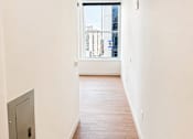 Thumbnail 13 of 14 - Hallway with hardwood flooring and city view window at Textile Lofts Apartments, Cincinnati, OH 45202