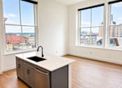 Thumbnail 8 of 14 - Studio apartment with kitchen island and city views at Textile Lofts Apartments, Cincinnati