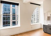 Thumbnail 6 of 14 - Empty studio with large windows and hardwood floors at Textile Lofts Apartments, Cincinnati, OH 45202