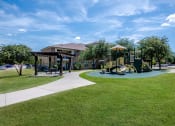 Thumbnail 8 of 43 - a playground in a park with a building in the background at Discovery at Craig Ranch, McKinney, Texas
