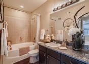Thumbnail 77 of 84 - a bathroom with a sink and a toilet and a tub  at Grand Villas Apartments, Texas