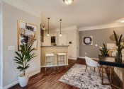 Thumbnail 52 of 84 - a living room and kitchen with a table and chairs  at Grand Villas Apartments, Katy, TX