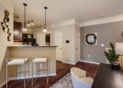 Thumbnail 72 of 84 - a kitchen and dining room with bar stools and breakfast bar  at Grand Villas Apartments, Texas