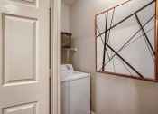 Thumbnail 82 of 84 - a small closet with a mirror and a washer and dryer in a bathroom at Grand Villas Apartments, Texas