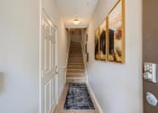 Thumbnail 81 of 84 - the entrance to a hallway with a staircase and a door leading up the stairs  at Grand Villas Apartments, Katy