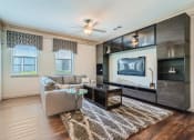 Thumbnail 56 of 84 - a living room with a couch and entertainment center  at Grand Villas Apartments, Katy, TX