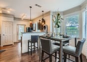 Thumbnail 58 of 84 - a kitchen with a bar and a table with chairs  at Grand Villas Apartments, Texas, 77494