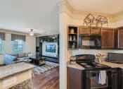 Thumbnail 53 of 84 - a kitchen and living room with a counter top  at Grand Villas Apartments, Texas, 77494