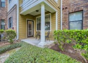 Thumbnail 66 of 84 - the front porch of a house with two chairs and a column  at Grand Villas Apartments, Katy