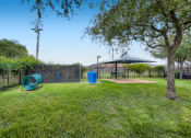 Thumbnail 23 of 84 - a park with a playground and a picnic table  at Grand Villas Apartments, Texas