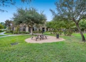 Thumbnail 25 of 84 - a park with a picnic table and trees in front of our apartments at Grand Villas Apartments, Texas, 77494