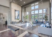 Thumbnail 20 of 43 - a living room with couches and tables and large windows at Discovery at Craig Ranch, McKinney, Texas