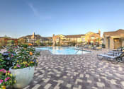 Thumbnail 13 of 38 - Daytime pool deck and exterior of apartments at Waterstone at Cinco Ranch, Texas, 77450