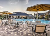 Thumbnail 15 of 38 - a resort style pool with tables and umbrellas at Waterstone at Cinco Ranch, Texas