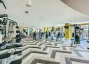 Thumbnail 8 of 24 - a gym with weights and cardio machines and a large window at Imperial Lofts, Sugar Land