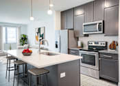 Thumbnail 1 of 73 - A modern kitchen with a large island and stainless steel appliances. at The MK, Indianapolis, IN, 46220