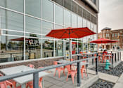 Thumbnail 5 of 43 - Table with chairs and Umbrella outside the building at 747 Apartments, Indiana, 46202