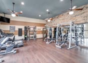 Thumbnail 49 of 59 - A gym with treadmills, weights, and exercise machines.