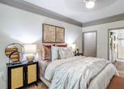 Thumbnail 6 of 47 - A bedroom with a bed, nightstand, and a painting on the wall at Avenues at Shadow Creek Ranch Apartments, Pearland, 77584