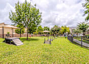 Thumbnail 27 of 47 - A park with a playground and a building in the background at Avenues at Shadow Creek Ranch Apartments, Pearland, Texas
