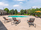 Thumbnail 25 of 57 - A pool surrounded by chairs and umbrellas with a building in the background. at CityView, North Kansas City, Missouri