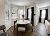 Thumbnail 26 of 84 - a small dining room with a table and chairs and windows at Grand Villas Apartments, Katy