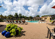 Thumbnail 2 of 47 - Pool area with a table and chairs at Grand Villas at Cinco Ranch, Texas, 77494