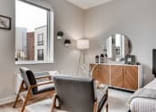 Thumbnail 9 of 65 - a bedroom with a large window and a chair and a desk with a mirror at Marquee, Minneapolis, Minnesota