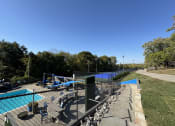 Thumbnail 7 of 21 - a view of a tennis court with a pool and a fence at The Boulevard, Roeland Park, KS