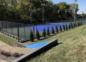 Thumbnail 8 of 21 - a tennis court with a fence around it and a blue pool at The Boulevard, Roeland Park, KS