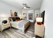 Thumbnail 36 of 84 - a bedroom with a bed and a ceiling fan at Grand Villas Apartments, Katy