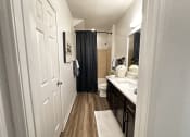 Thumbnail 35 of 84 - a bathroom with a shower and a sink and a toilet at Grand Villas Apartments, Katy