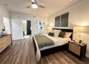 Thumbnail 44 of 84 - a bedroom with a bed and a ceiling fan at Grand Villas Apartments, Katy