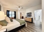 Thumbnail 34 of 84 - a bedroom with a large bed and a ceiling fan at Grand Villas Apartments, Katy